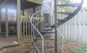 A retouched photo of a boy standing on metal stairs, hid head cut out of the shot.